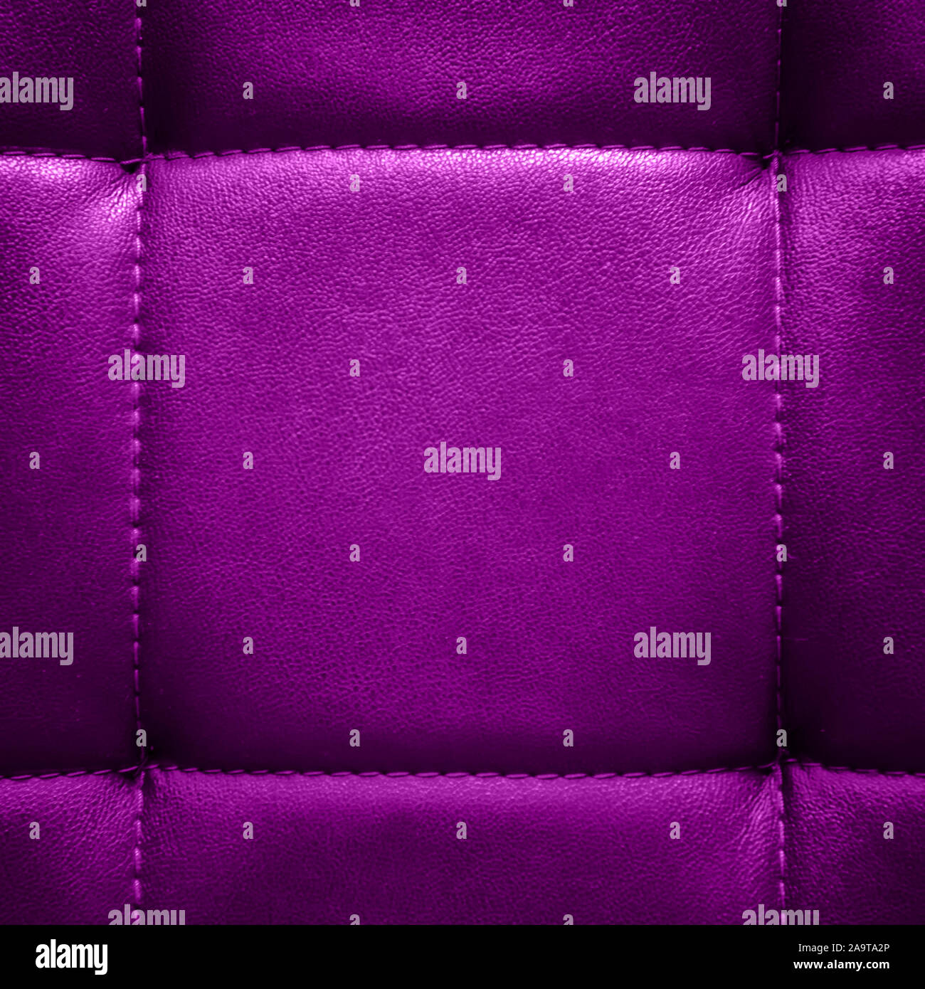 Shiny dark lilac artificial textured leather stitched with thread. Close-up of sofa surface. View from directly above. Highly detailed square backgrou Stock Photo
