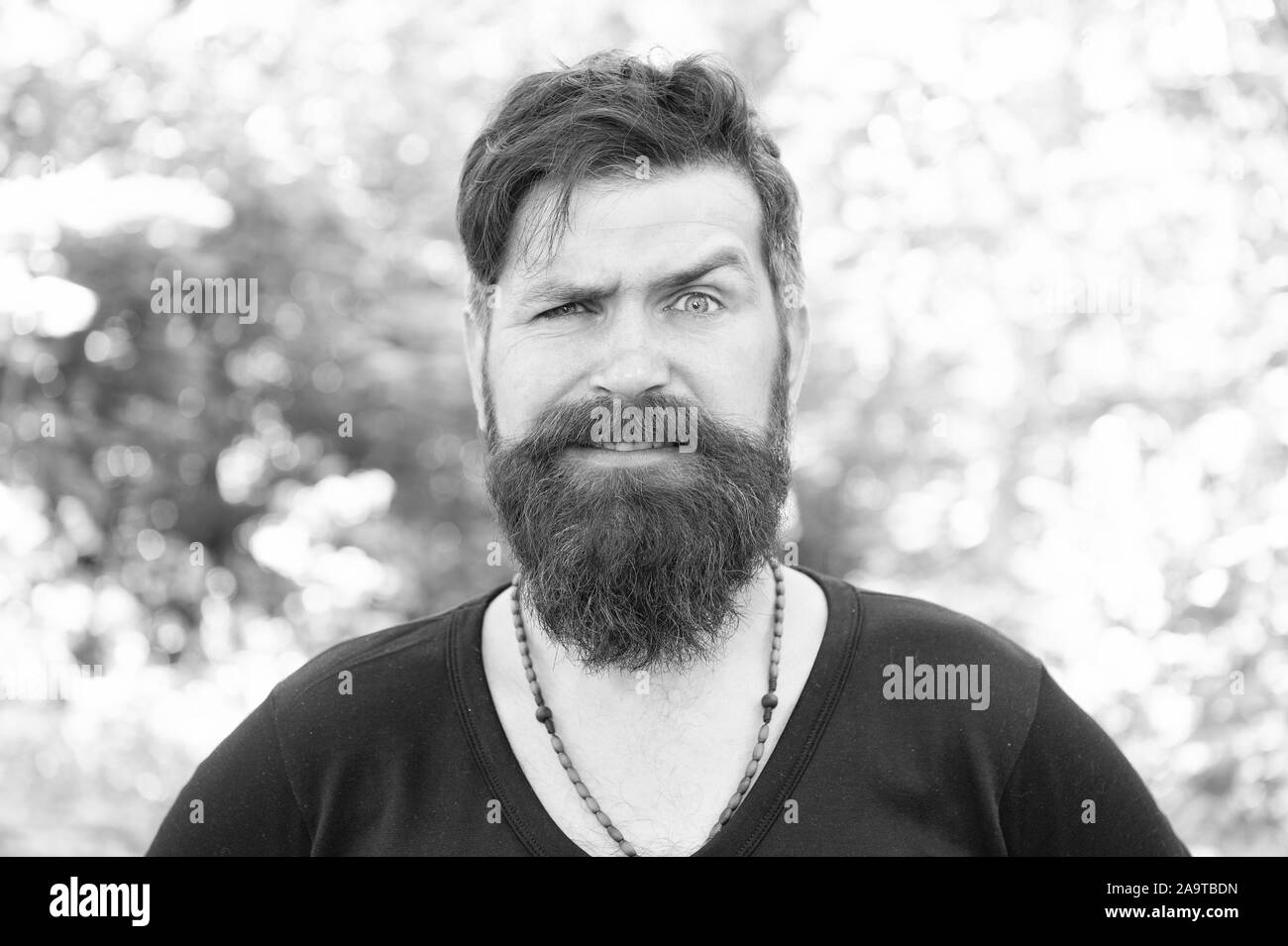 Wild nature. Man bearded hipster bright foliage background. Guy relax in summer forest. Handsome man with beard and mustache summer vacation. Brutality of jungles concept. Summer heat season concept. Stock Photo