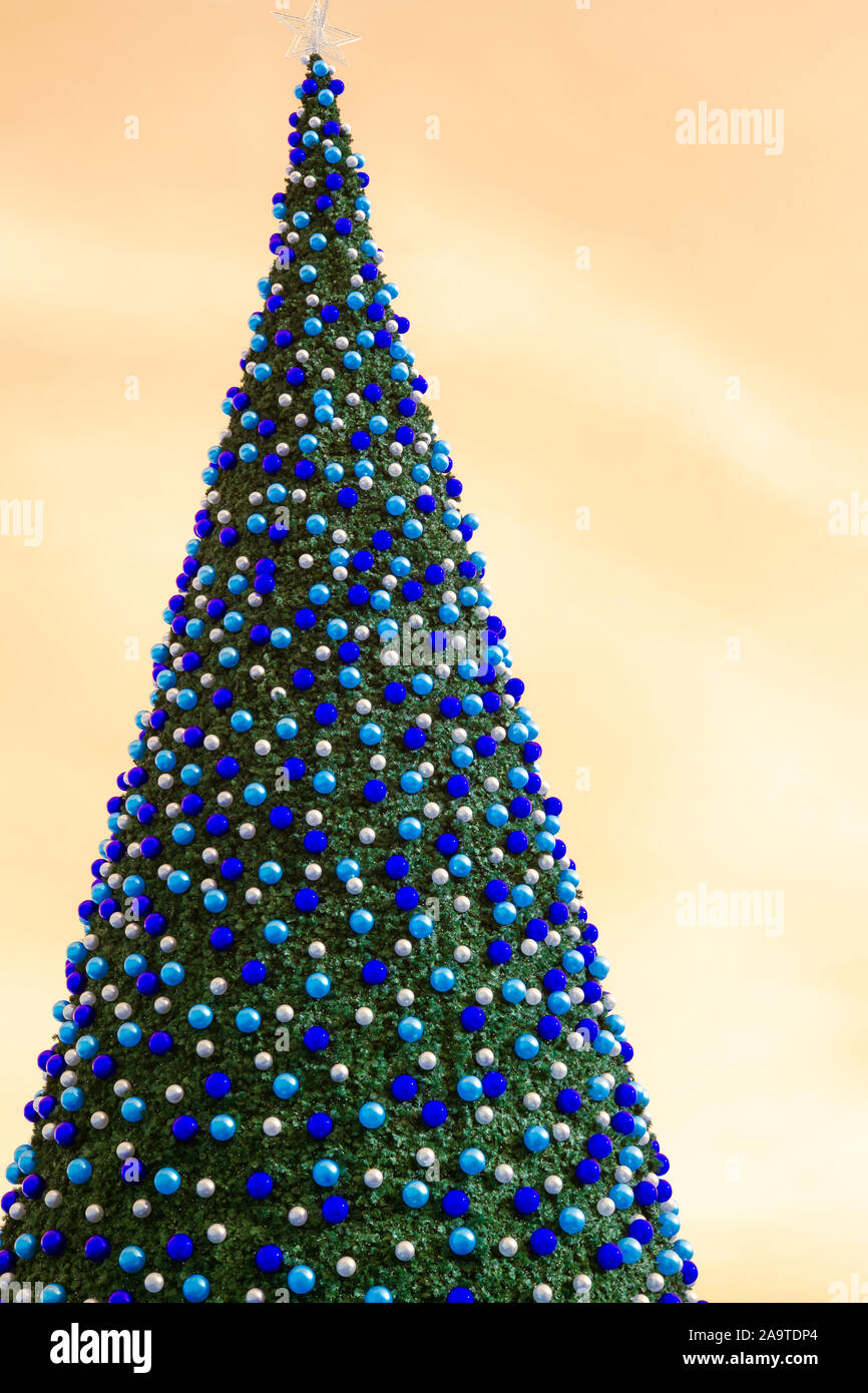 christmas tree with decorates balls and large beautiful star at the top with orange sky Stock Photo