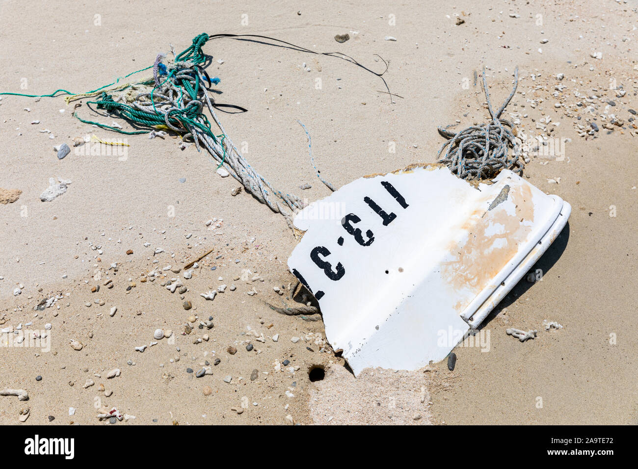 Flotsam, rope and piece of a boat, on a sand beach Stock Photo