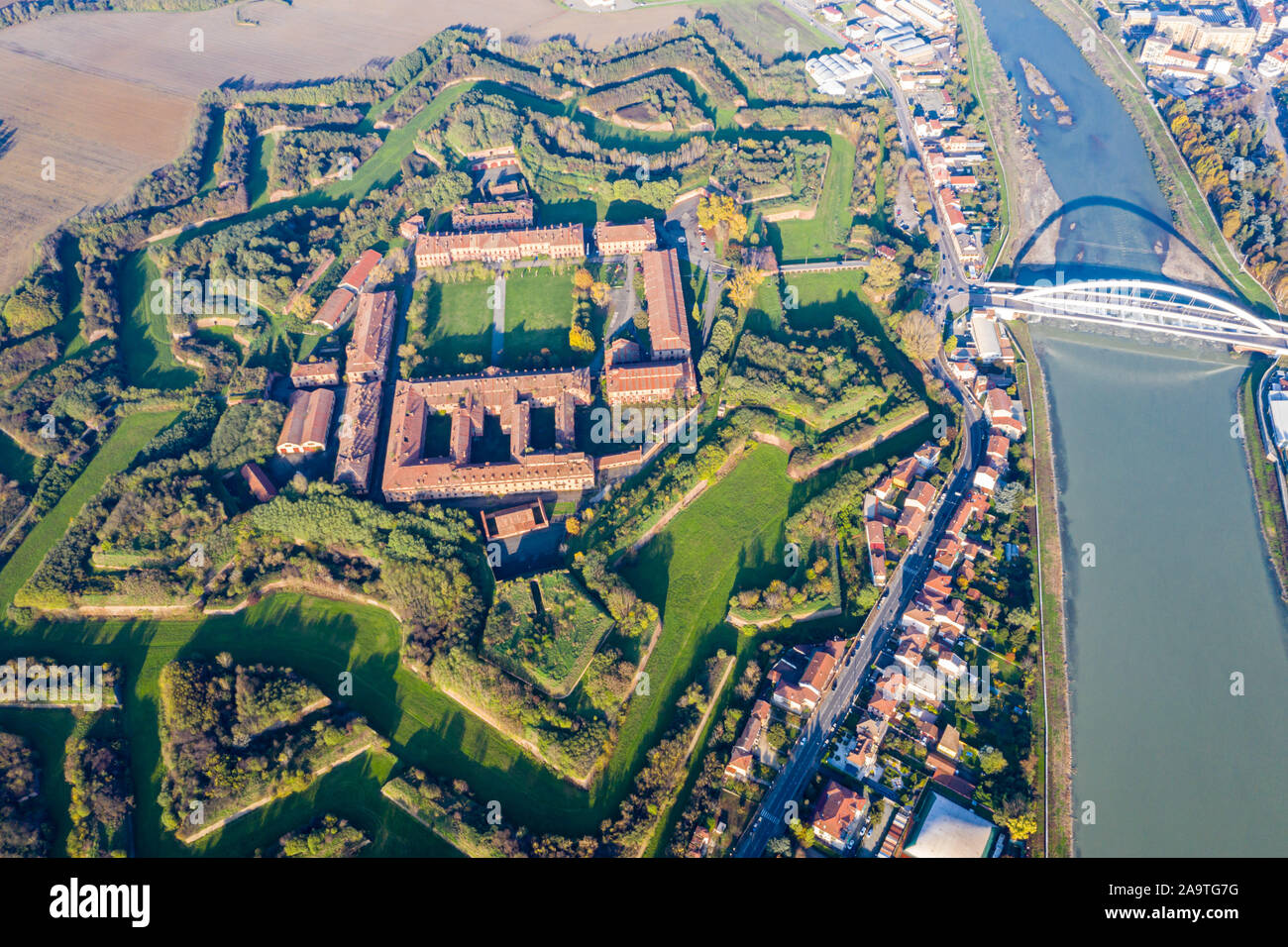 Aerial view of walls and bastions of modern six-star hexagon shaped fort Cittadella of Alessandria on winding river Tanaro. Piedmont, Italy. Bridge Po Stock Photo