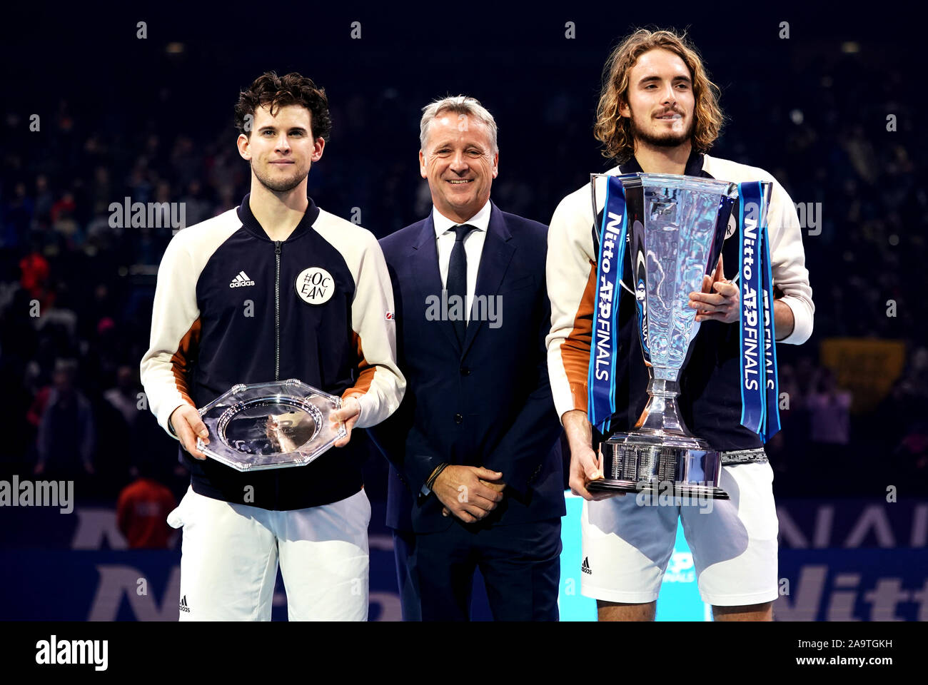 Stefanos Tsitsipas (right) celebrates with the trophy after victory against Dominic Thiem (left) in the singles final, alongside ATP Chairman Chris Kermode (centre) on day eight of the Nitto ATP Finals at