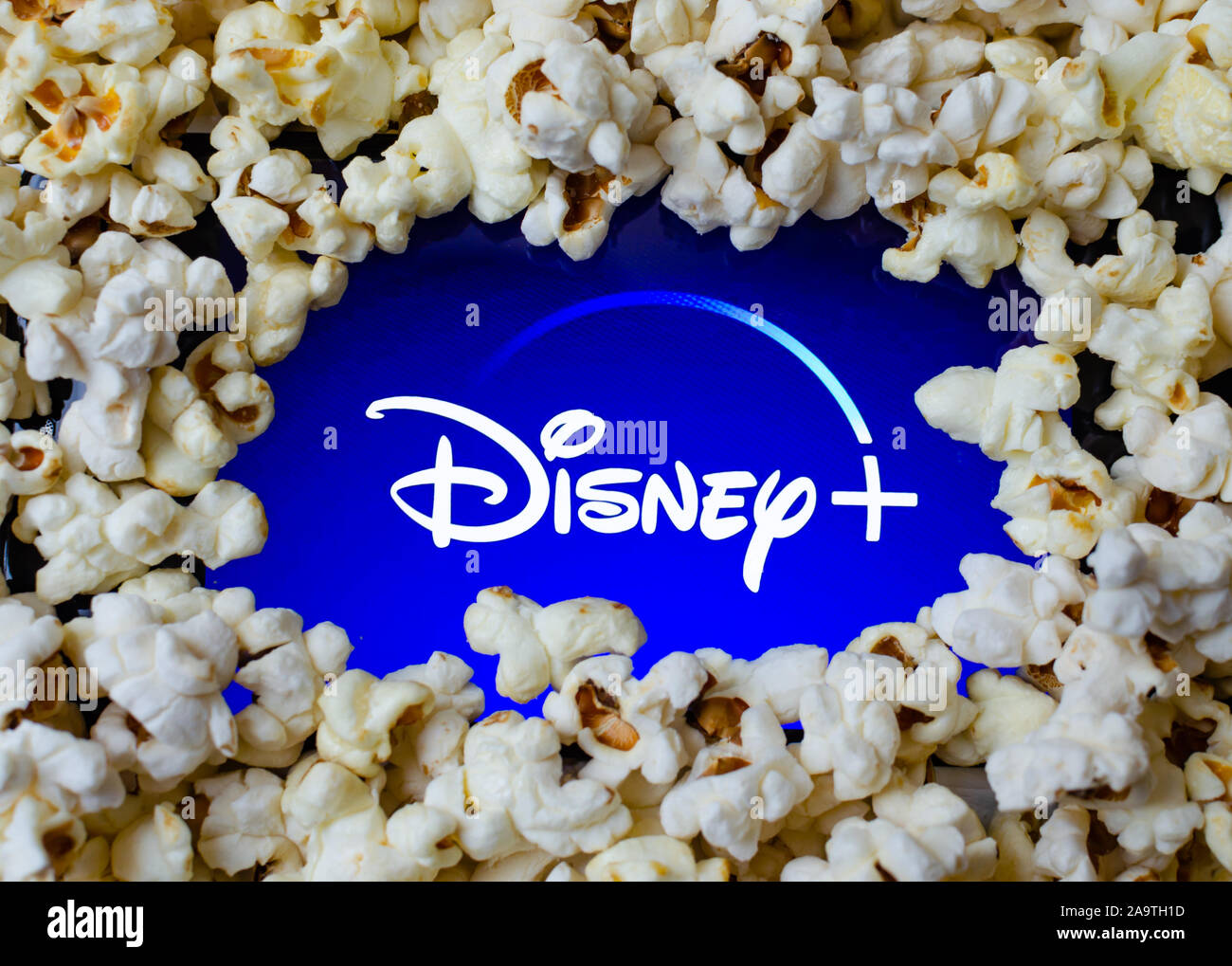Disney+ logo on a screen covered with popcorn. Concept photo for home entertainment and new video streaming service. Stock Photo