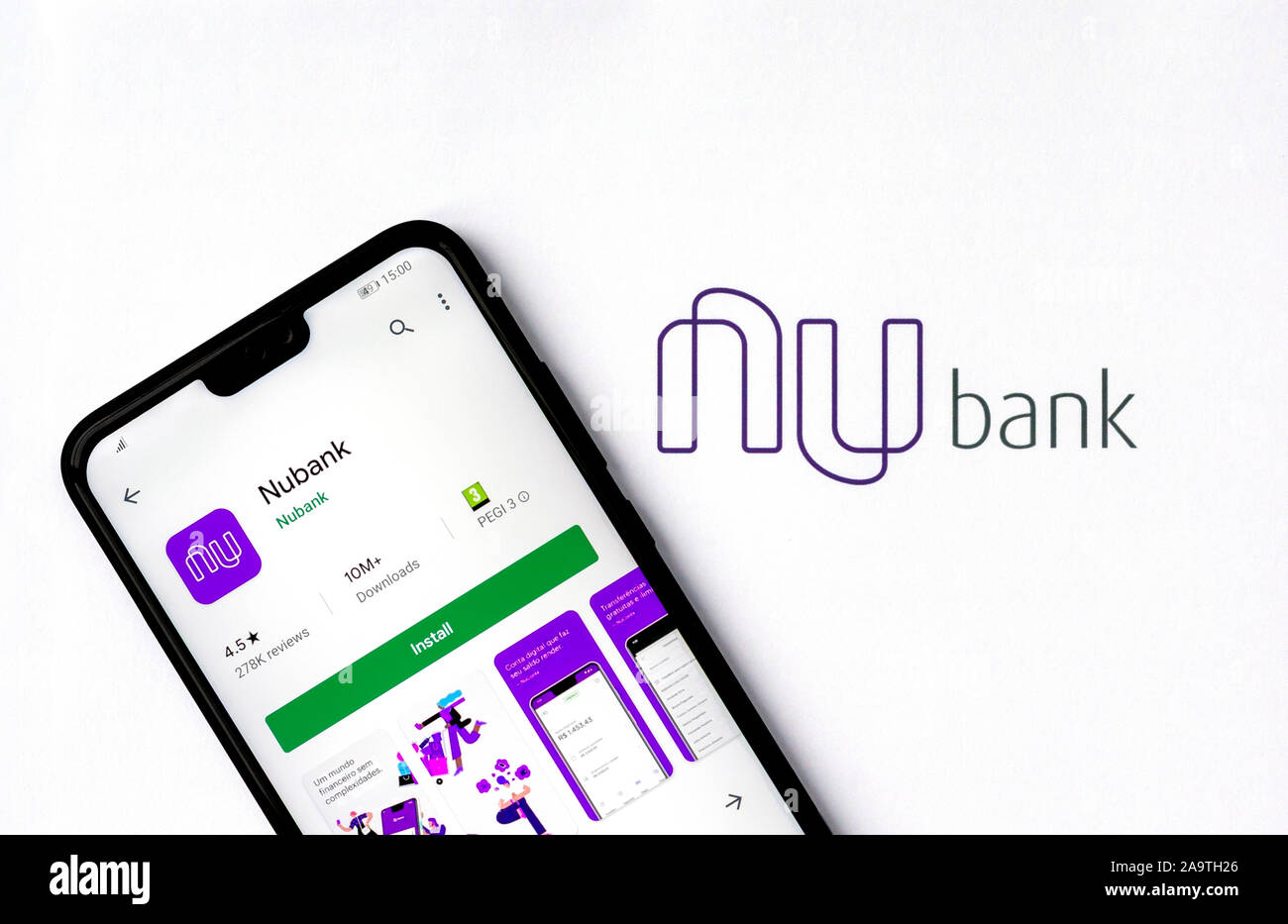 Nubank logo on a brochure and the cell phone with Nubank app on the screen. Stock Photo