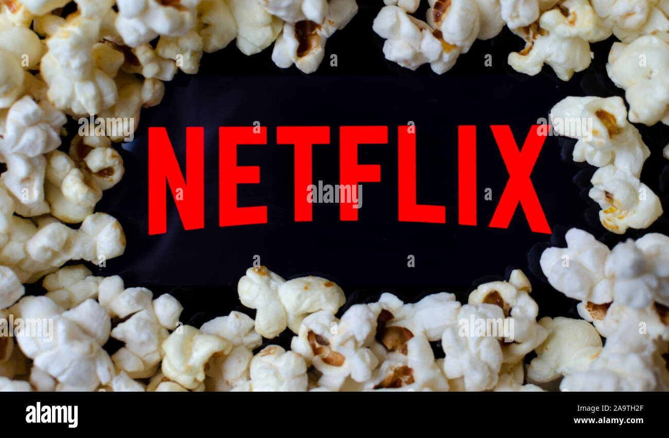 Netflix logo on a screen covered with popcorn. Concept photo for home entertainment. Stock Photo