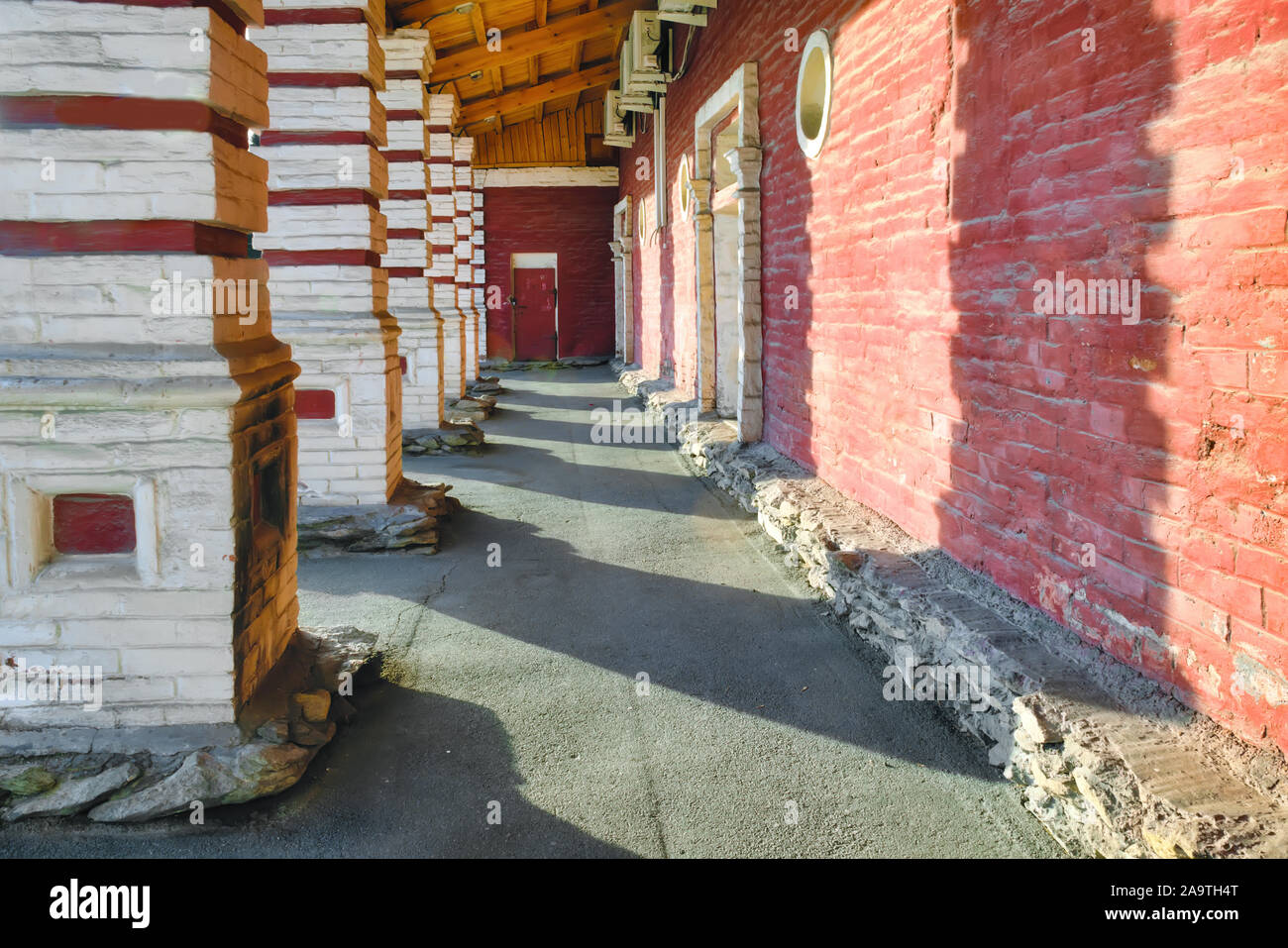 Fragment of an old building with red brick columns. Fragment of the old house. Stock Photo