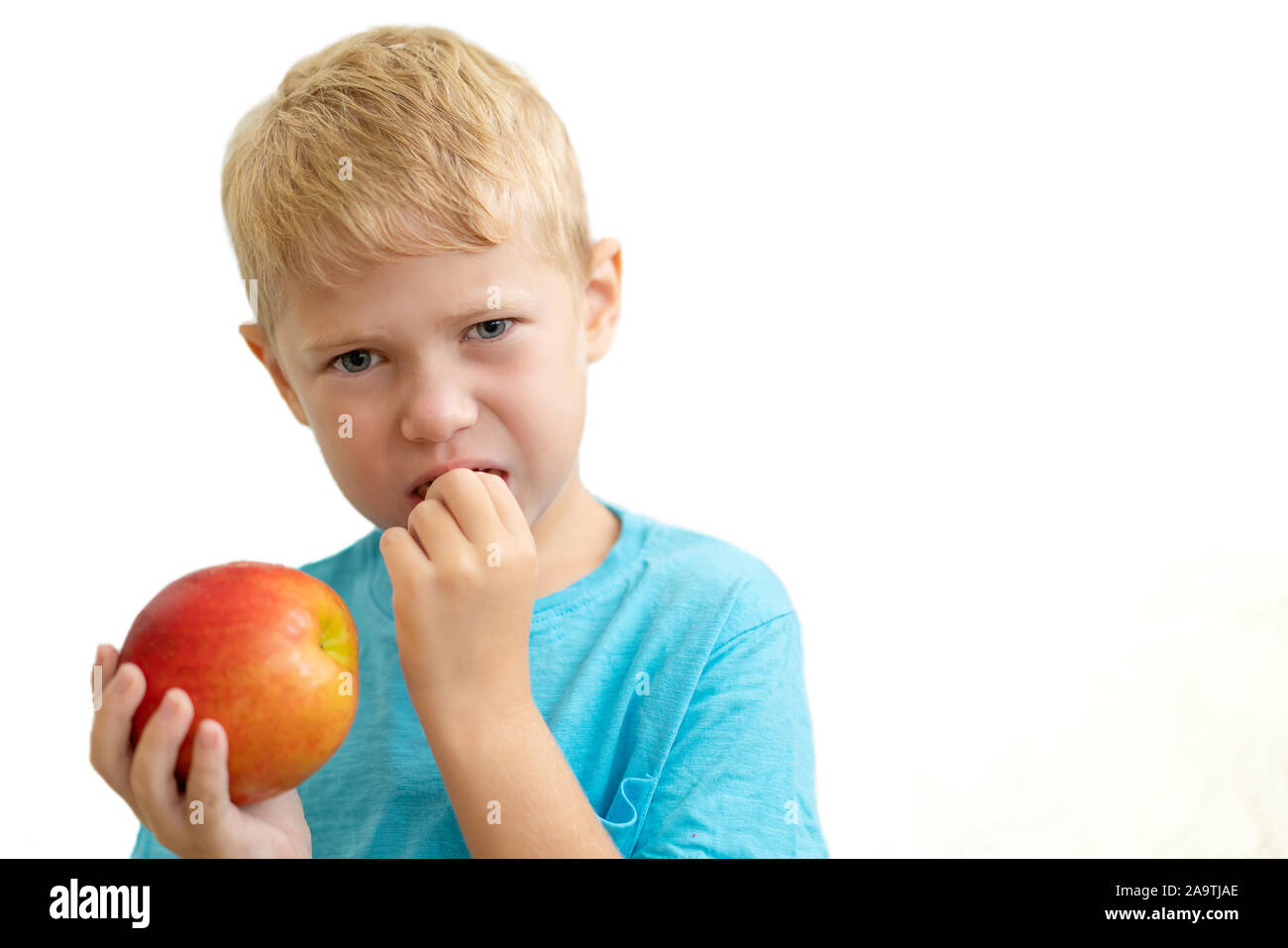 Little boy have problem with his teeth while eat apple. Isolated on