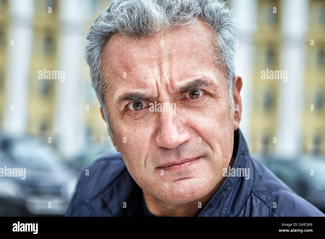 A well-groomed man with the appearance of an official and an angry reproachful look with irritation looks into the photographers lens against the back Stock Photo