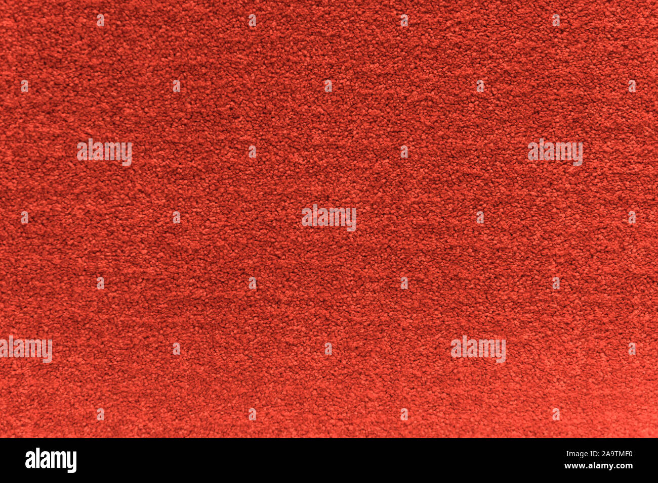 Red artificial carpet texture close-up, top view. Stock Photo