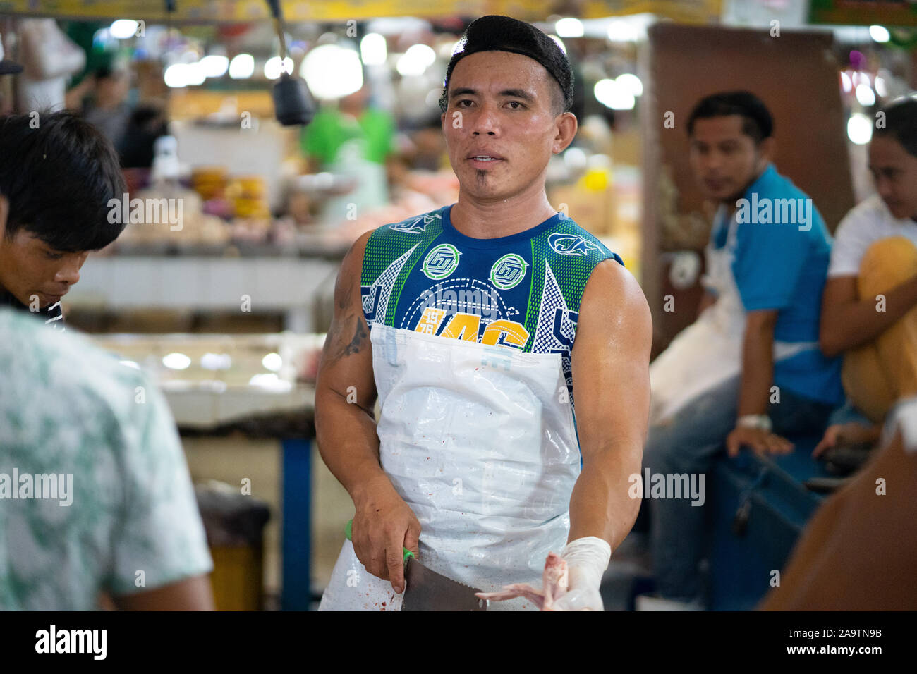 Candid Portrait of a muscular Young Filipino man working in a market,Cebu City,Philippines Stock Photo