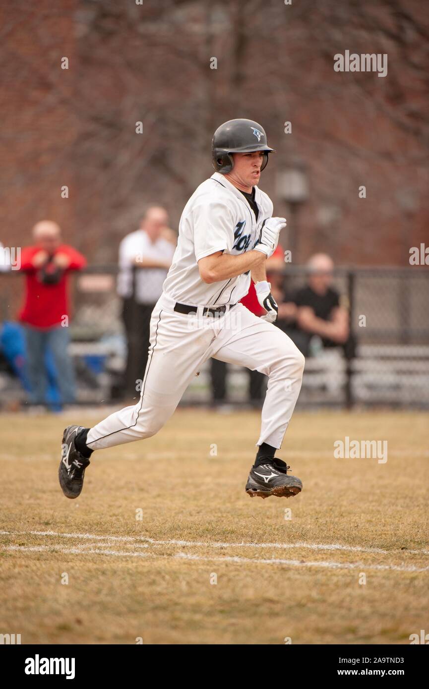 Full-length profile shot of a Johns Hopkins University Men's Baseball team player, running to reach a base during a match with Rutgers University, March 7, 2009. From the Homewood Photography Collection. () Stock Photo