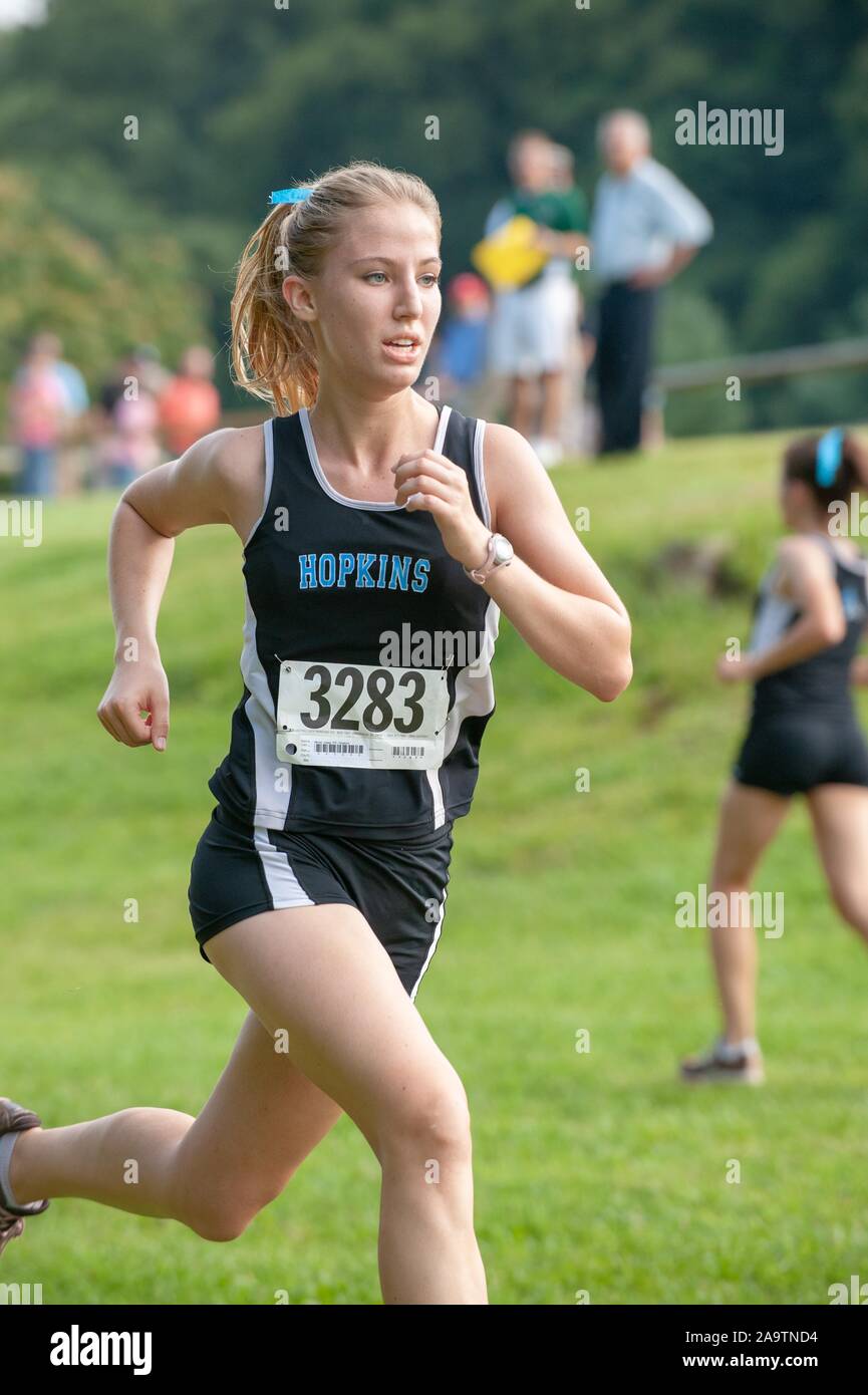 Three-quarter length shot of a Johns Hopkins University Women's Cross Country team member, outside on a sunny day, running in the Baltimore Metro Invitational, September 4, 2009. From the Homewood Photography Collection. () Stock Photo