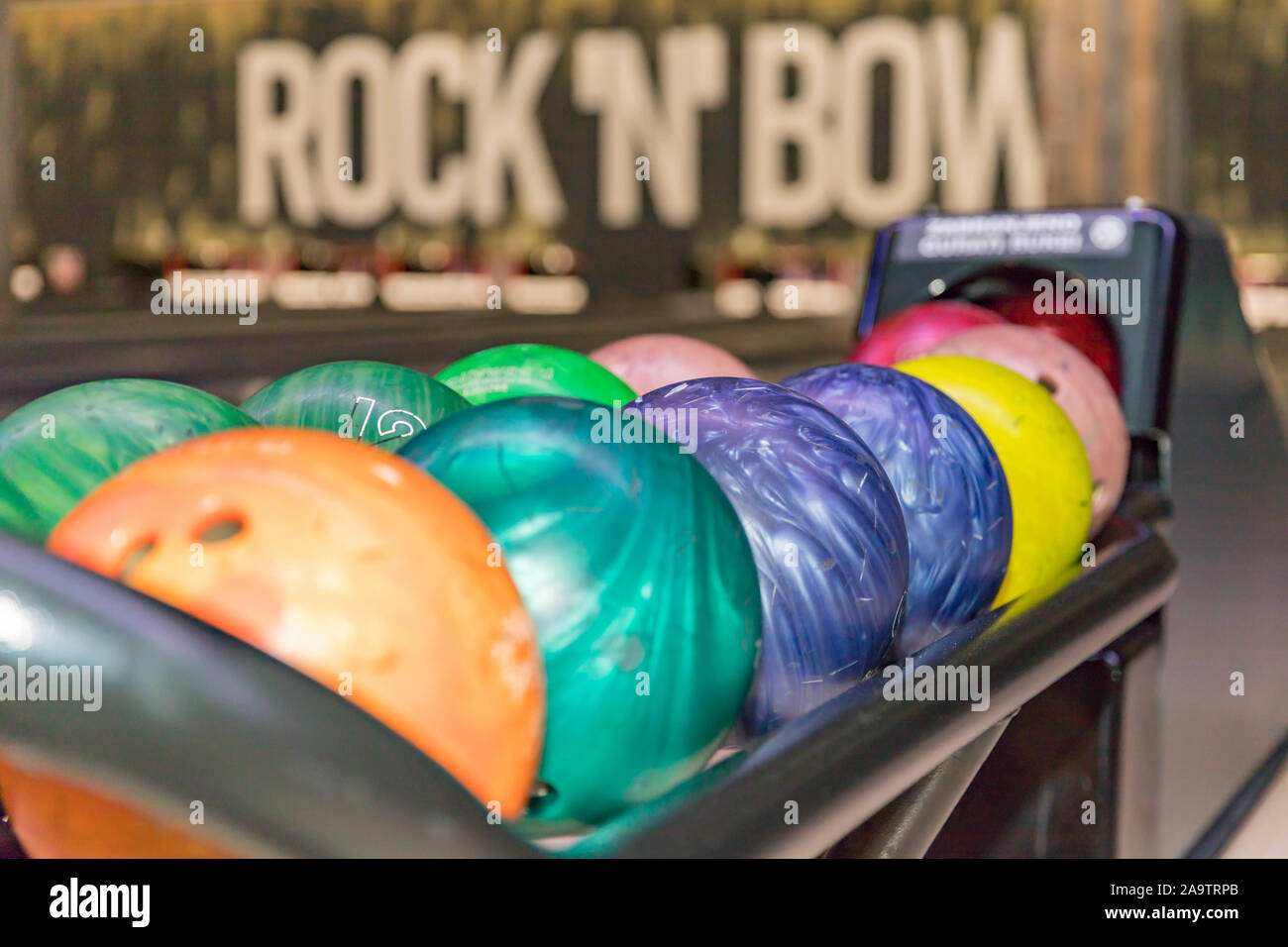Close up of bowling balls and bowling pins in bowling club. Bowling pins and balls in a row Stock Photo