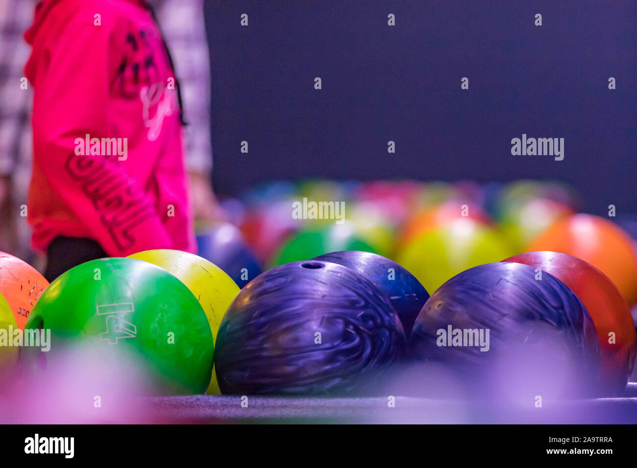 Close up of bowling balls and bowling pins in bowling club. Bowling pins and balls in a row Stock Photo