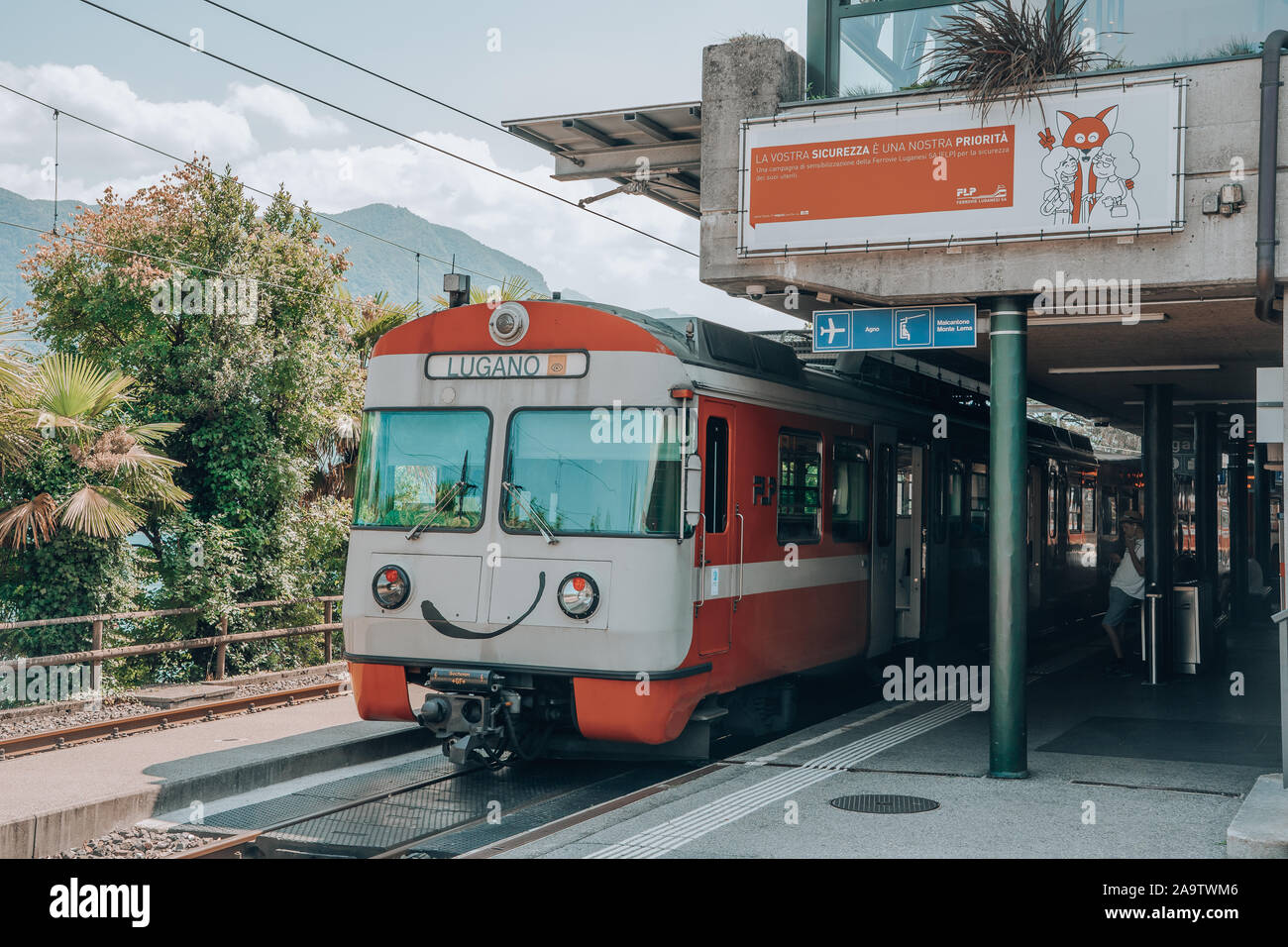 Lugano, Switzerland - August 4, 2019: Tourists are boarding on the train in Lugano Train station Stock Photo