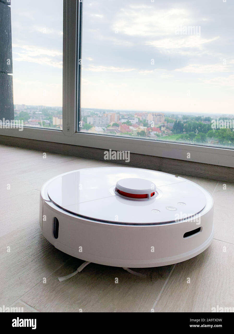 White robot cleaner. Robot vacuum cleaner on laminate floor in action Stock Photo Alamy