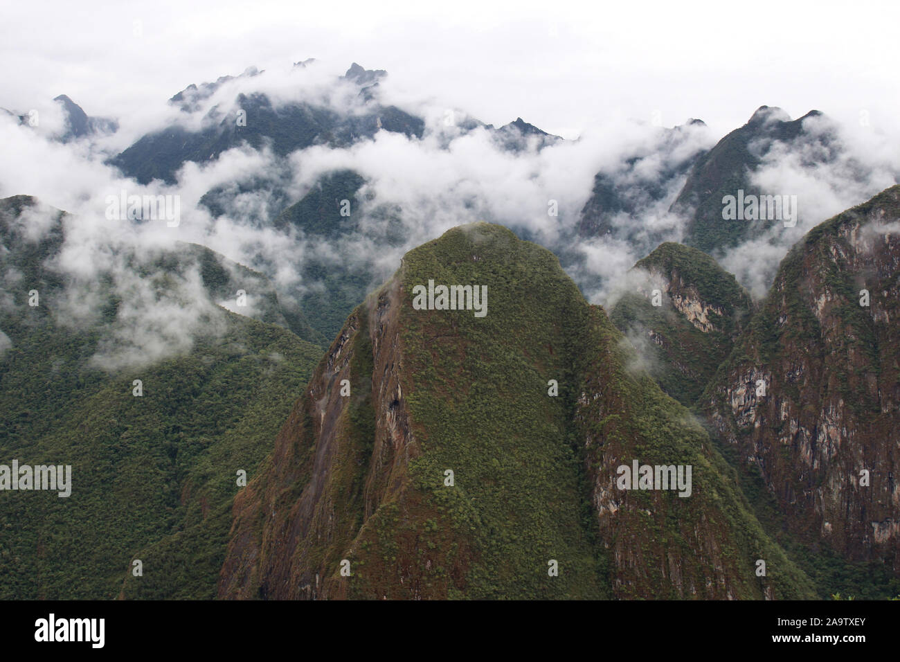 Clouds descending upon the mountain peaks of the Andes, the Vilcabamba range, in the Machupicchu District of Peru, South America, viewed from atop Hua Stock Photo