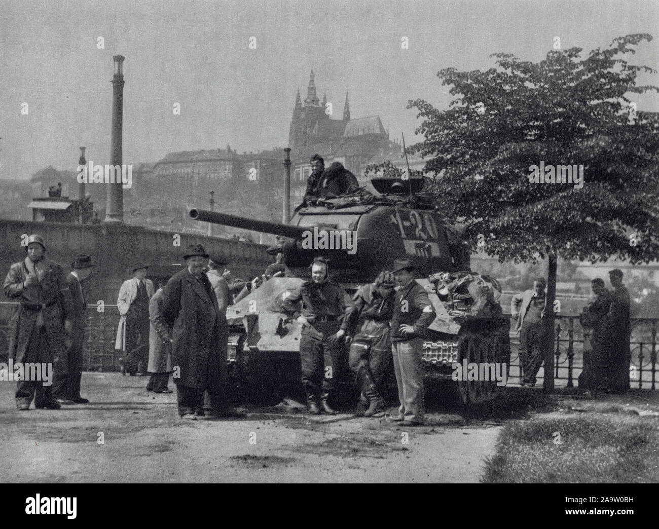 Red Army tank T-34 on the embankment of the Vltava River next to the Mánes Bridge (Mánesův most) in Prague, Czechoslovakia, in May 1945. Black and white photograph by Czech photographer Oldřich Smola taken probably on 9 May 1945 and published in the Czechoslovak book 'The Heart of Prague on Fire' ('Srdce Prahy v plamenech') issued in 1946. Courtesy of the Azoor Postcard Collection. Stock Photo