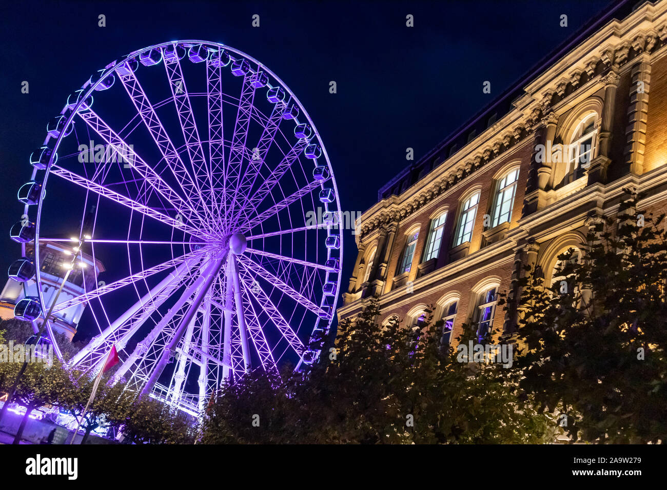 Illuminated feeris wheel and building of Office of Economic Development in Düsseldorf, North Rhine-Westphalia, Germany, Europe Stock Photo
