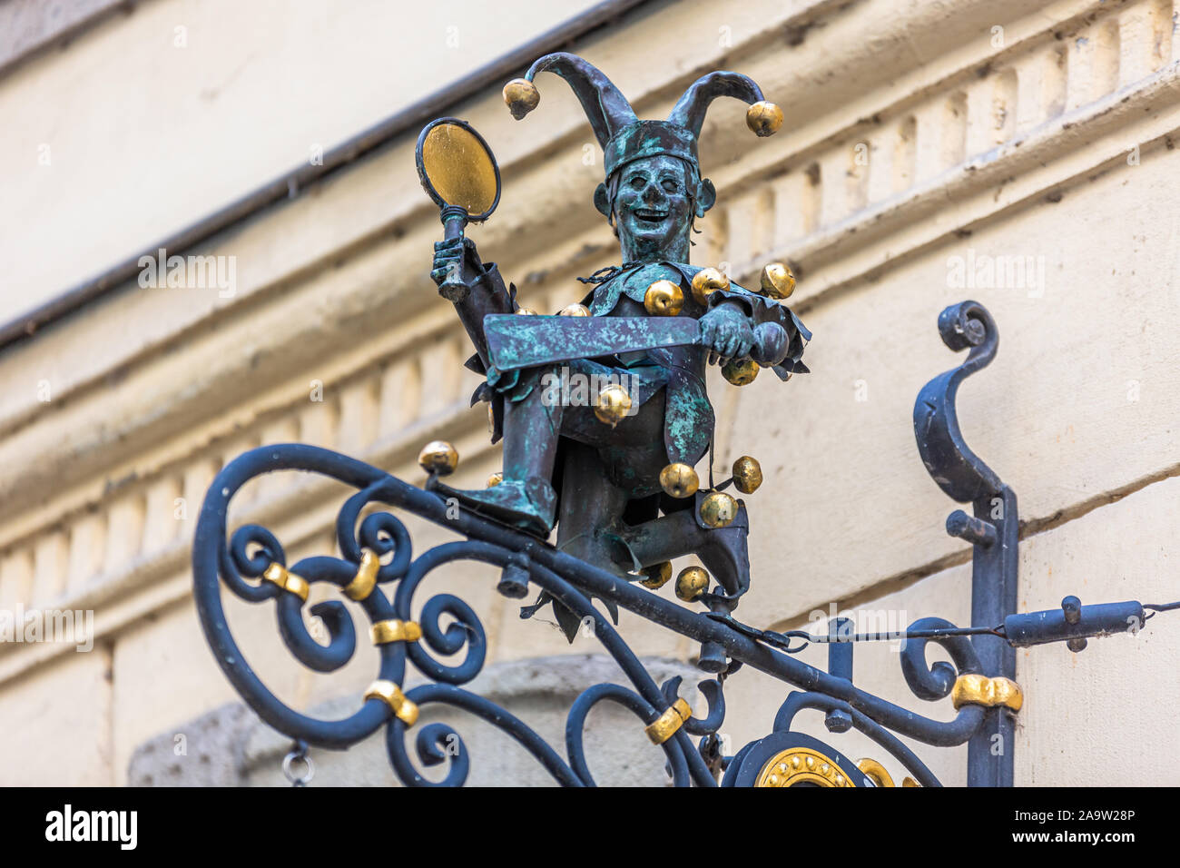Jester figure wearing, fool's cap, mirror, clap and bells on facade of House of Carnival in historical district old town of Düsseldorf, Germany Stock Photo