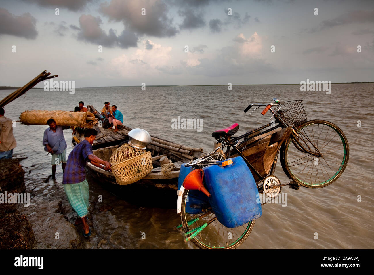 homeless people of Nijhum Dweep make their way across to the mainland having lost their home to river erosion Stock Photo