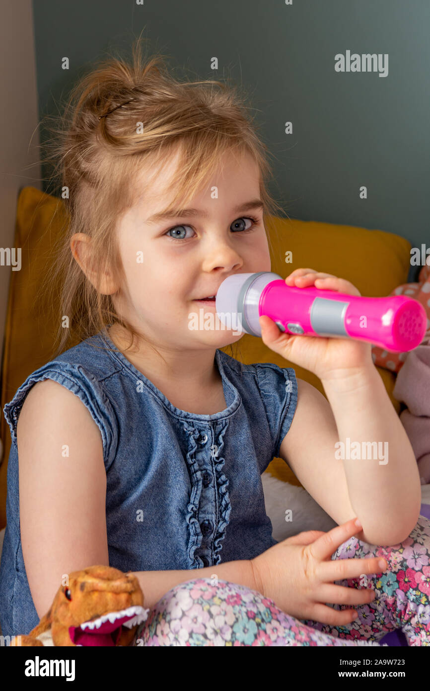 Cute little girl playing with musical instrument. Stock Photo