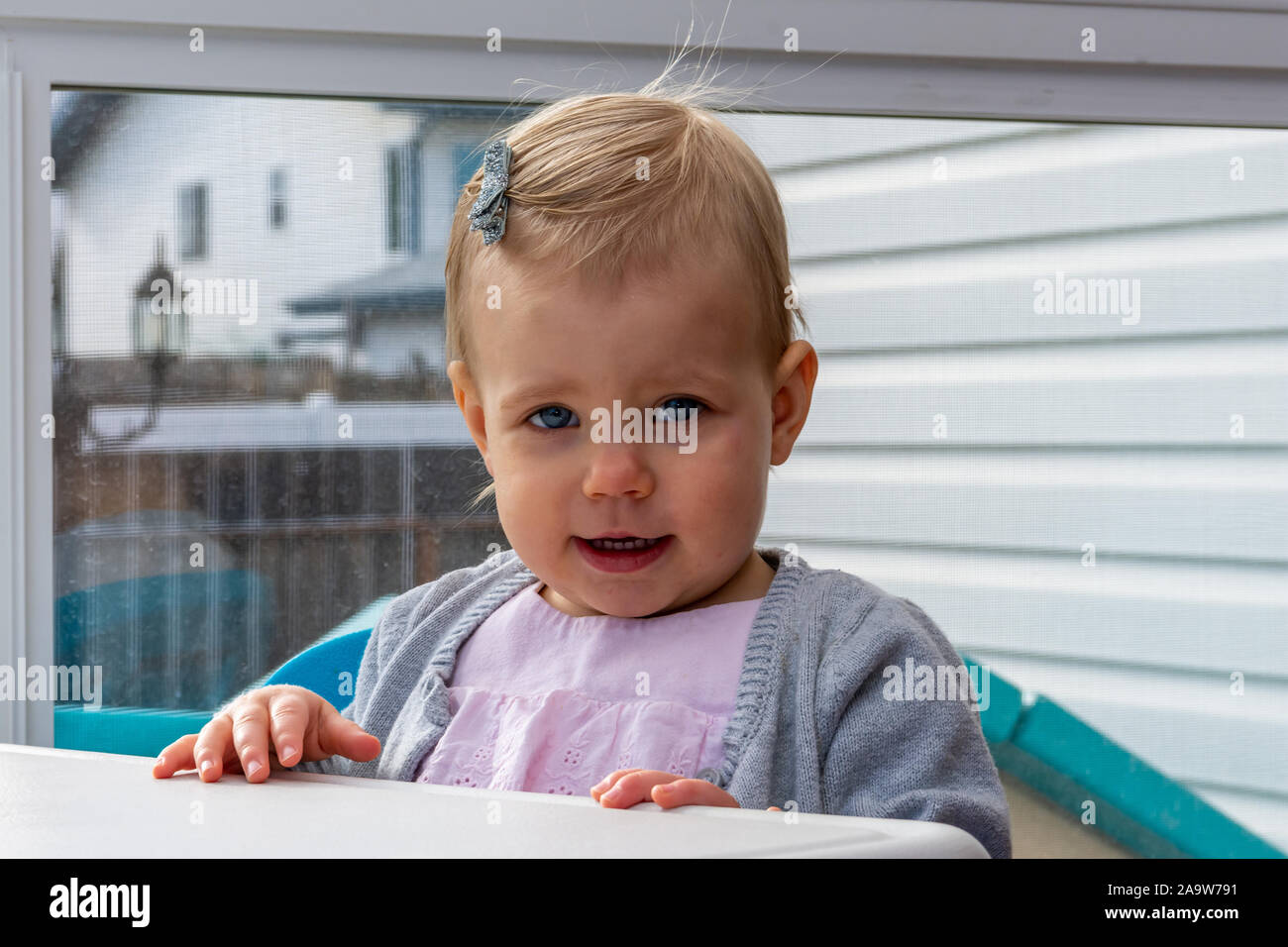 Blue eyed, blonde little girl with a cute, innocent look, close up. Stock Photo