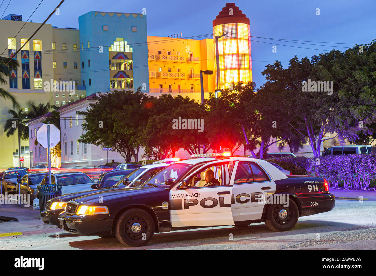 Miami Beach Florida,Collins Avenue,police car,policeman,dusk,evening,night,making out accident report,FL100123061 Stock Photo