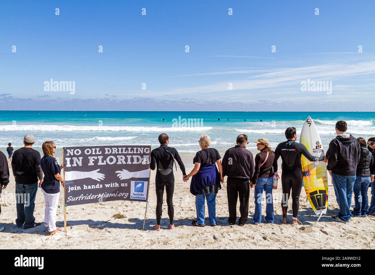 Miami Beach Florida,Surfrider Foundation,No Offshore Florida Oil Drilling Protest,Black clothing represents oil,sign,hold hand,hands,Atlantic Ocean,wa Stock Photo
