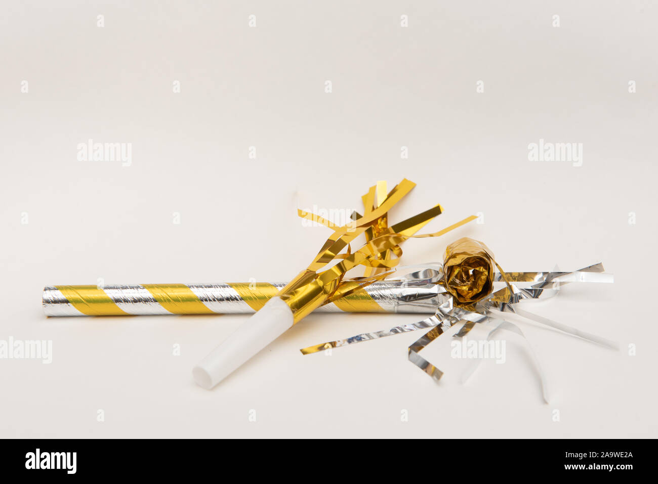 Isolated yellow party blowers on white background Stock Photo - Alamy