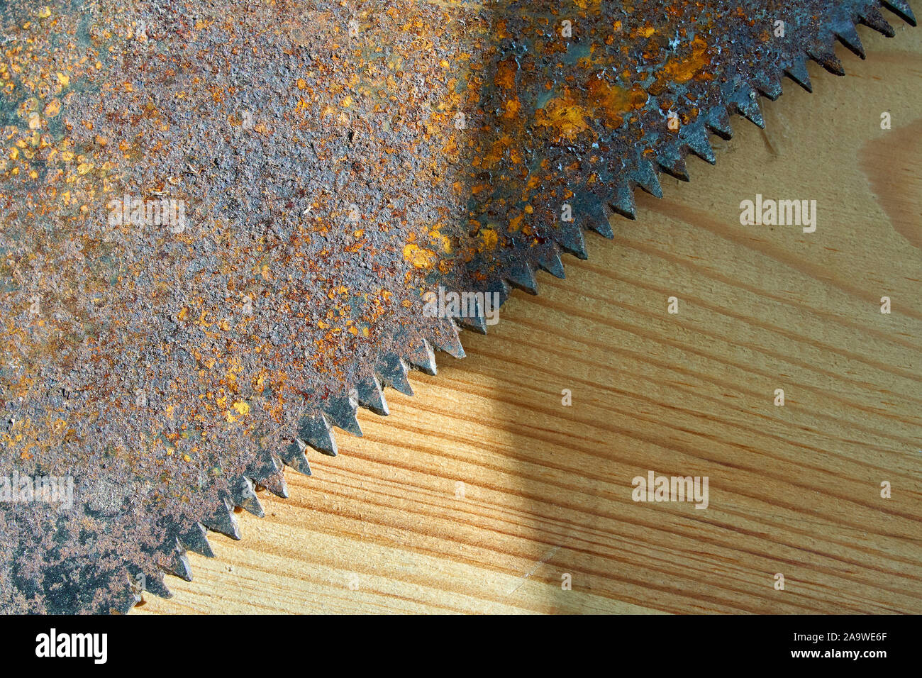 Old hand saw on a dirty wooden background.Working area with hand tool.Carpentry instrument. Stock Photo