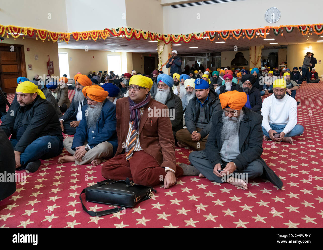 New York, NY - November 17, 2019: Men pray during 550th Birthday of Guru Nanak Dev Ji celebration at Sikh Cultural Society Stock Photo