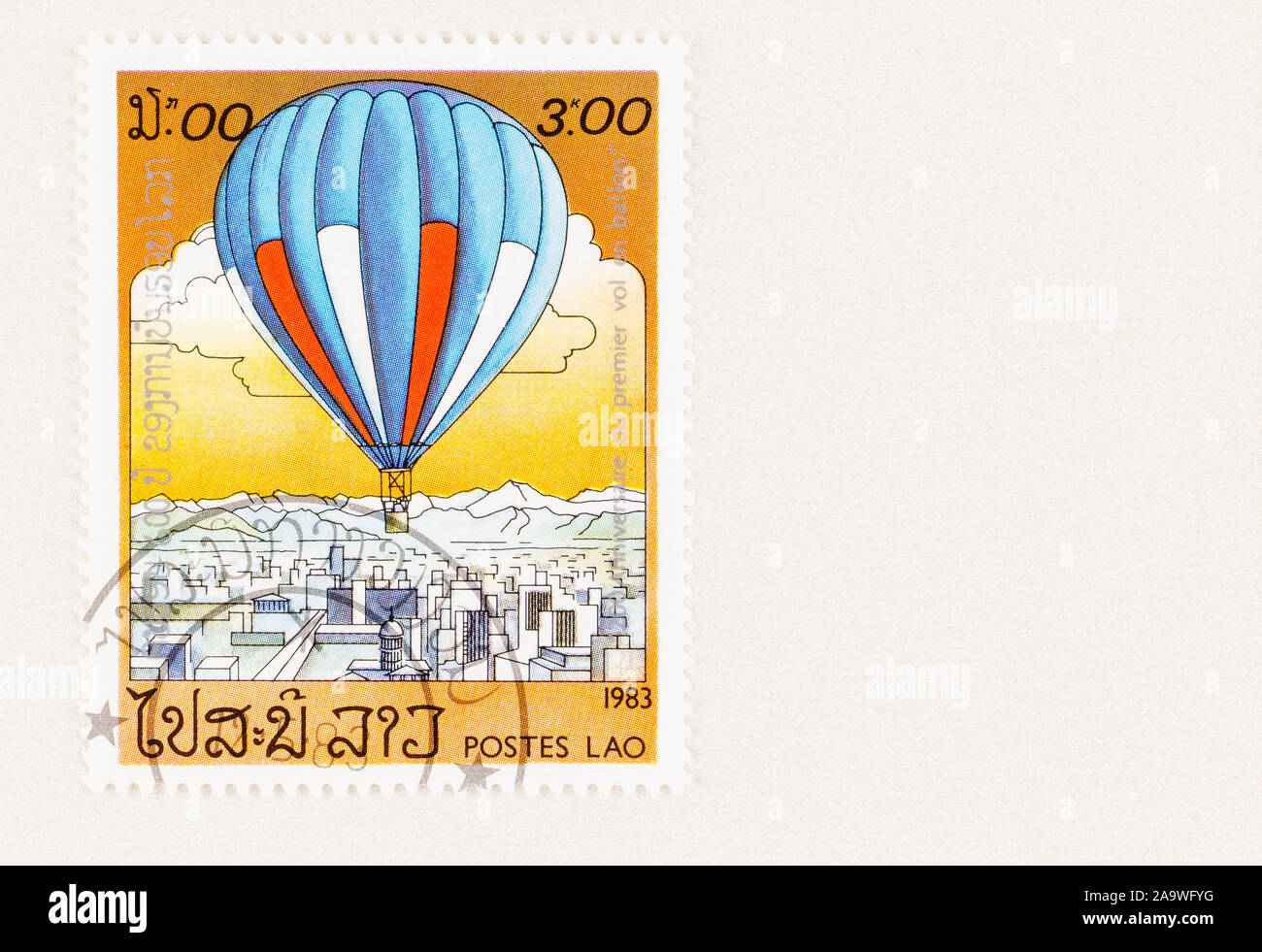 SEATTLE WASHINGTON - October 5, 2019: Blue,red and white hot air balloon floating over city on Laos postage stamp issued in 1983. Stock Photo