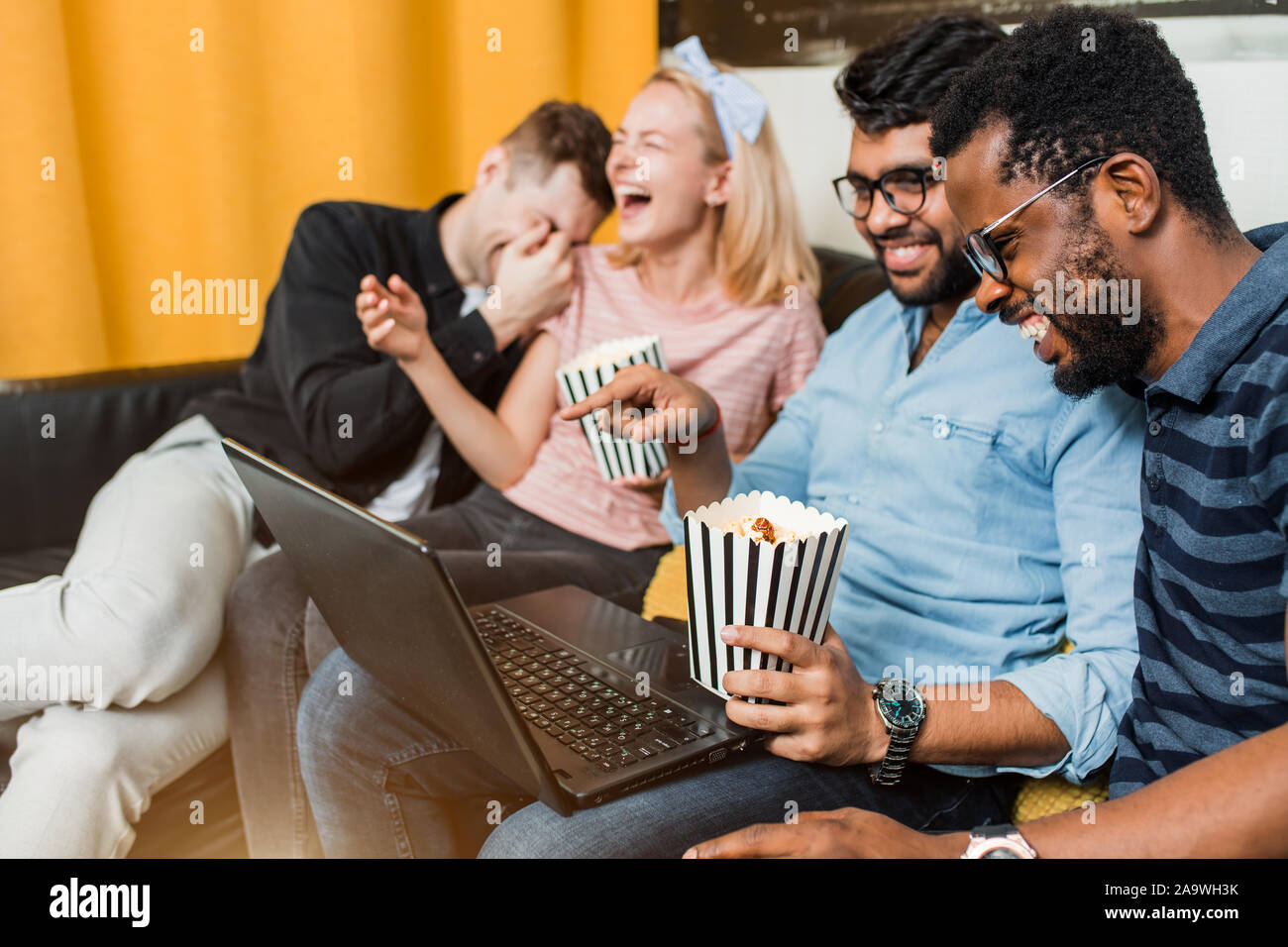 Happy diverse friends students group looking at laptop and mobile