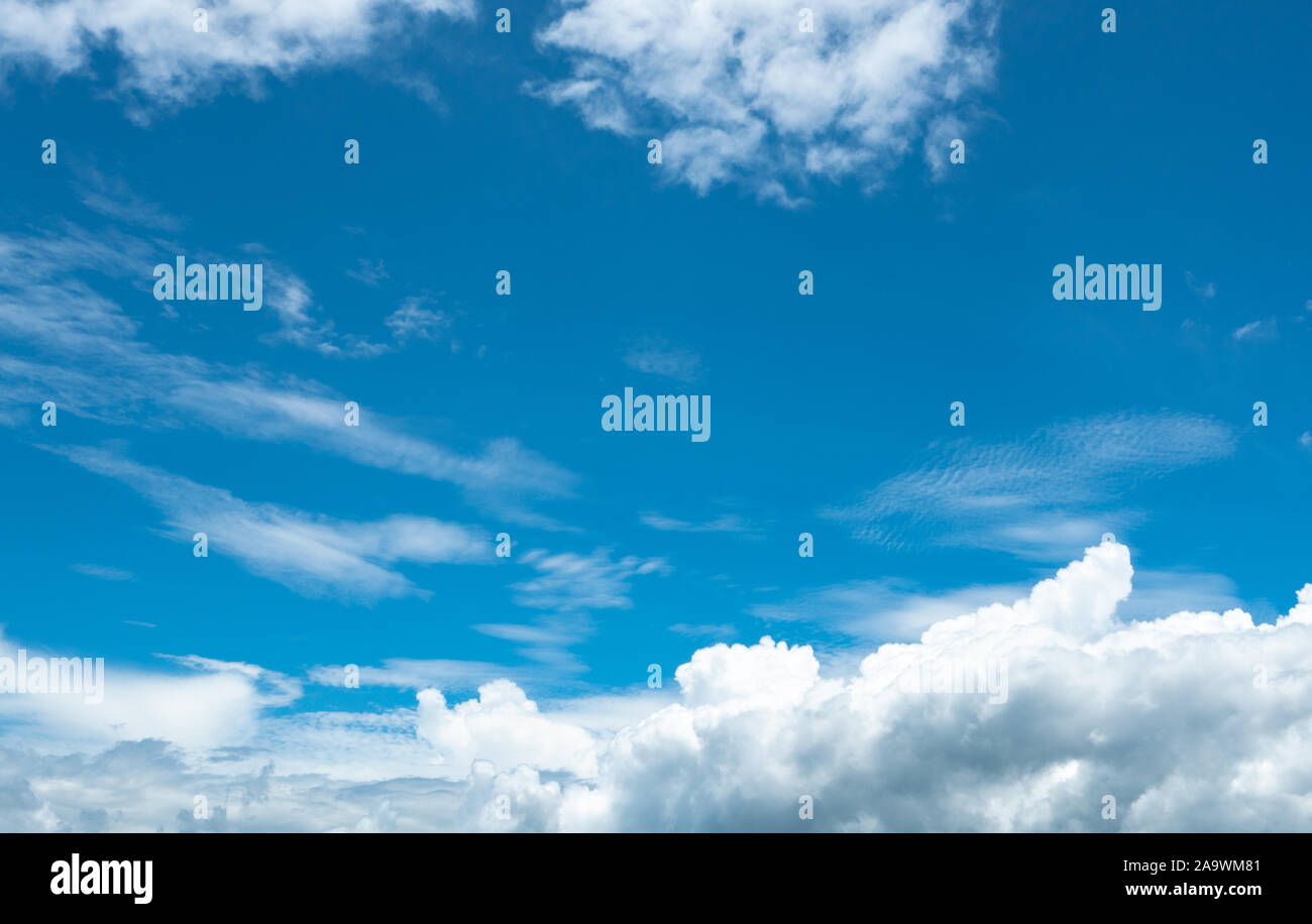 Beautiful blue sky and white cumulus clouds abstract background. Cloudscape background. Blue sky and fluffy white clouds on sunny day. Nature weather. Stock Photo