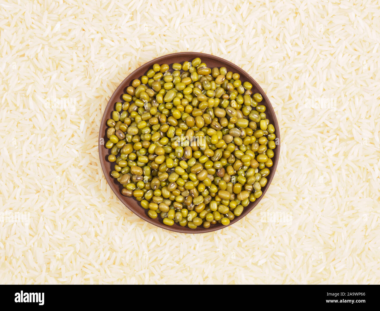 Green gram in clay plate. Background from basmati rice. Indian cuisine ingredients Stock Photo