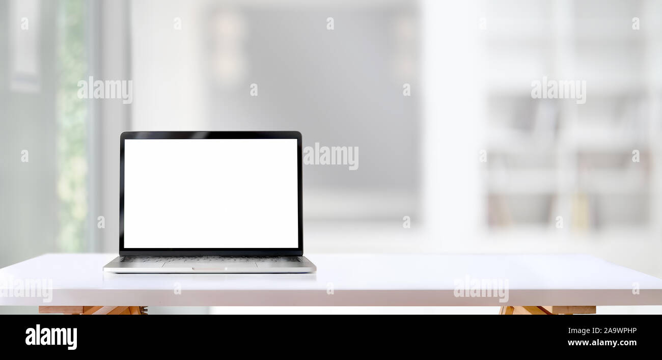 Open blank screen laptop computer on white wooden table with living ...