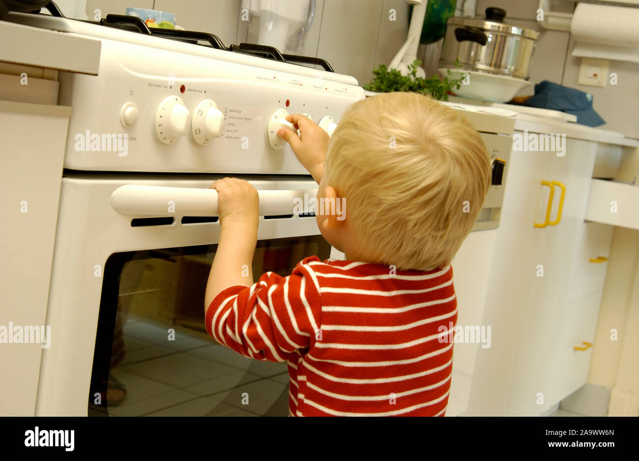Child playing with cooker dial Stock Photo