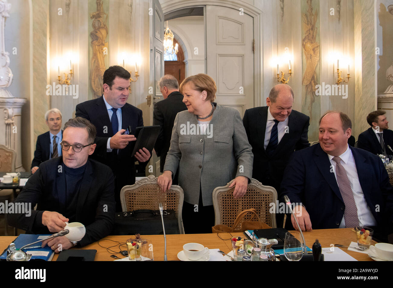 18 November 2019, Brandenburg, Meseberg: Federal Chancellor Angela Merkel (M, CDU) talks to Hubertus Heil (second row l, SPD), Federal Minister of Labour and Social Affairs, before the start of the federal government's closed session at Meseberg Castle. On the left is Heiko Maas (SPD), Foreign Minister, on the right Olaf Scholz (2nd from right, SPD), Federal Minister of Finance, and Helge Braun (r, CDU), Minister of the Chancellor's Office. The focus of the closed conference in the guest house of the Federal Government in Meseberg is digital change. Photo: Monika Skolimowska/dpa-Zentralbild/dp Stock Photo