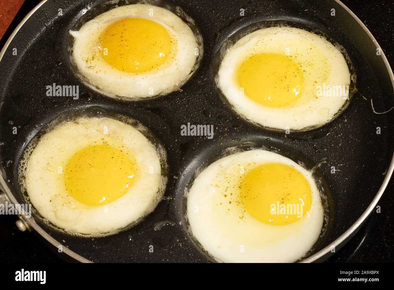 Four frying eggs in a frying pan Stock Photo Alamy
