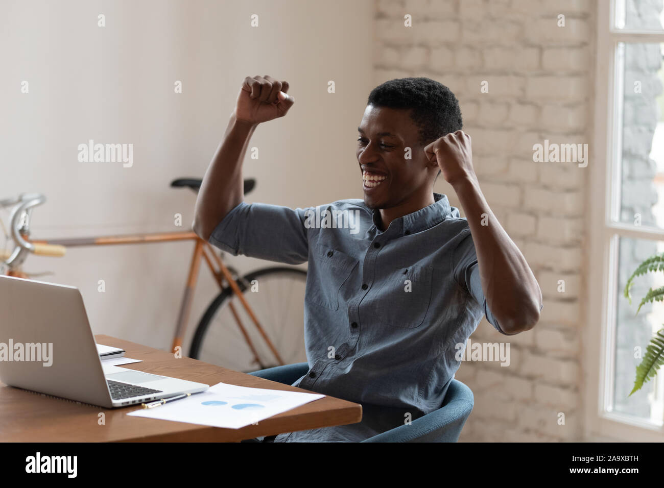 Overjoyed mixed race businessman celebrating corporate success. Stock Photo