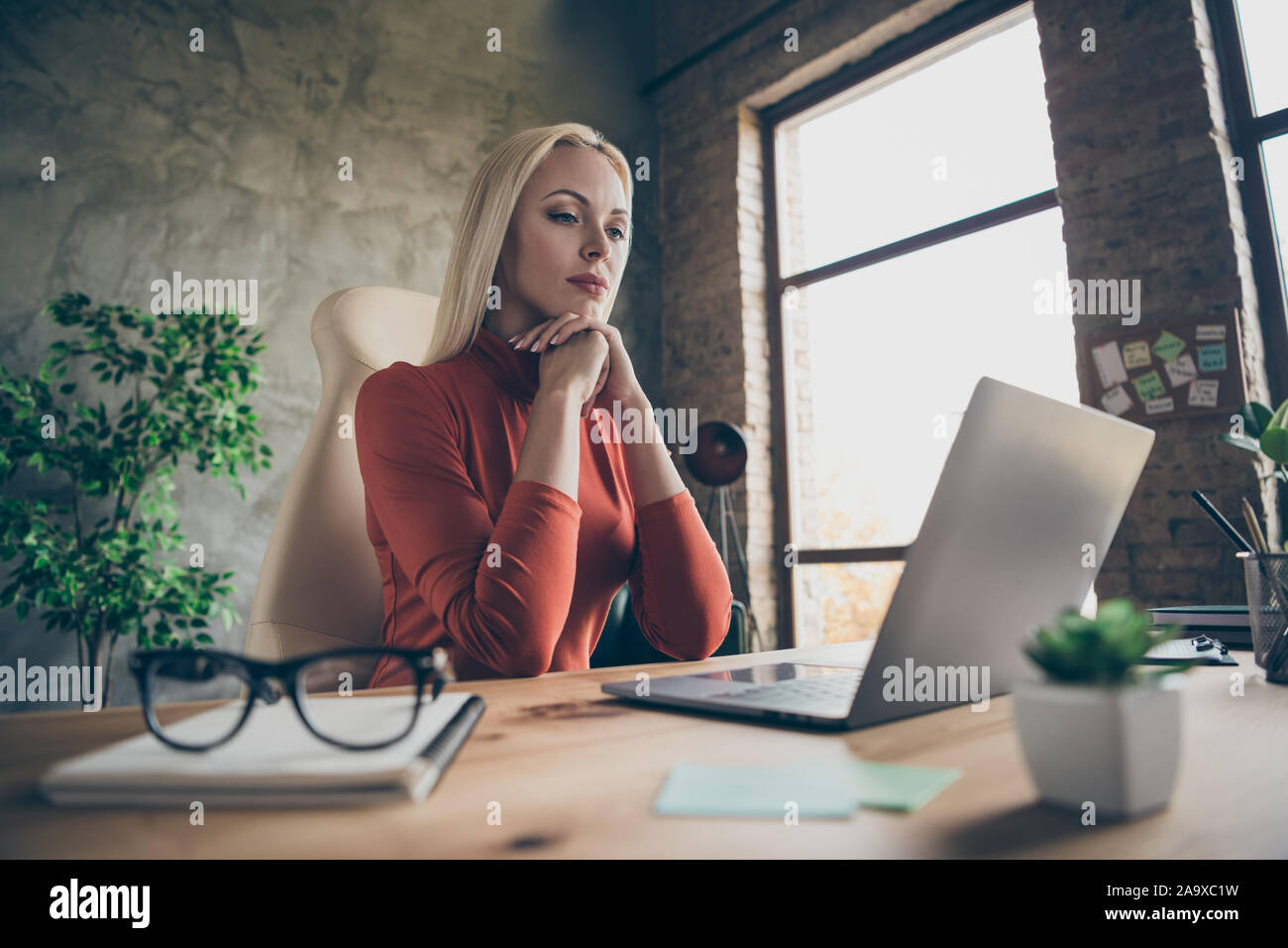 Photo of confident thoughtful woman looking through searched information to analyze most important details Stock Photo