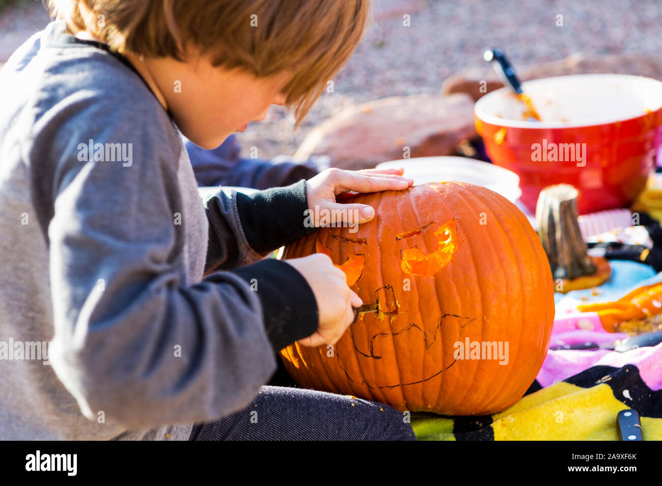 A six year old boy carving pumpkin outdoors at Halloween Stock Photo ...