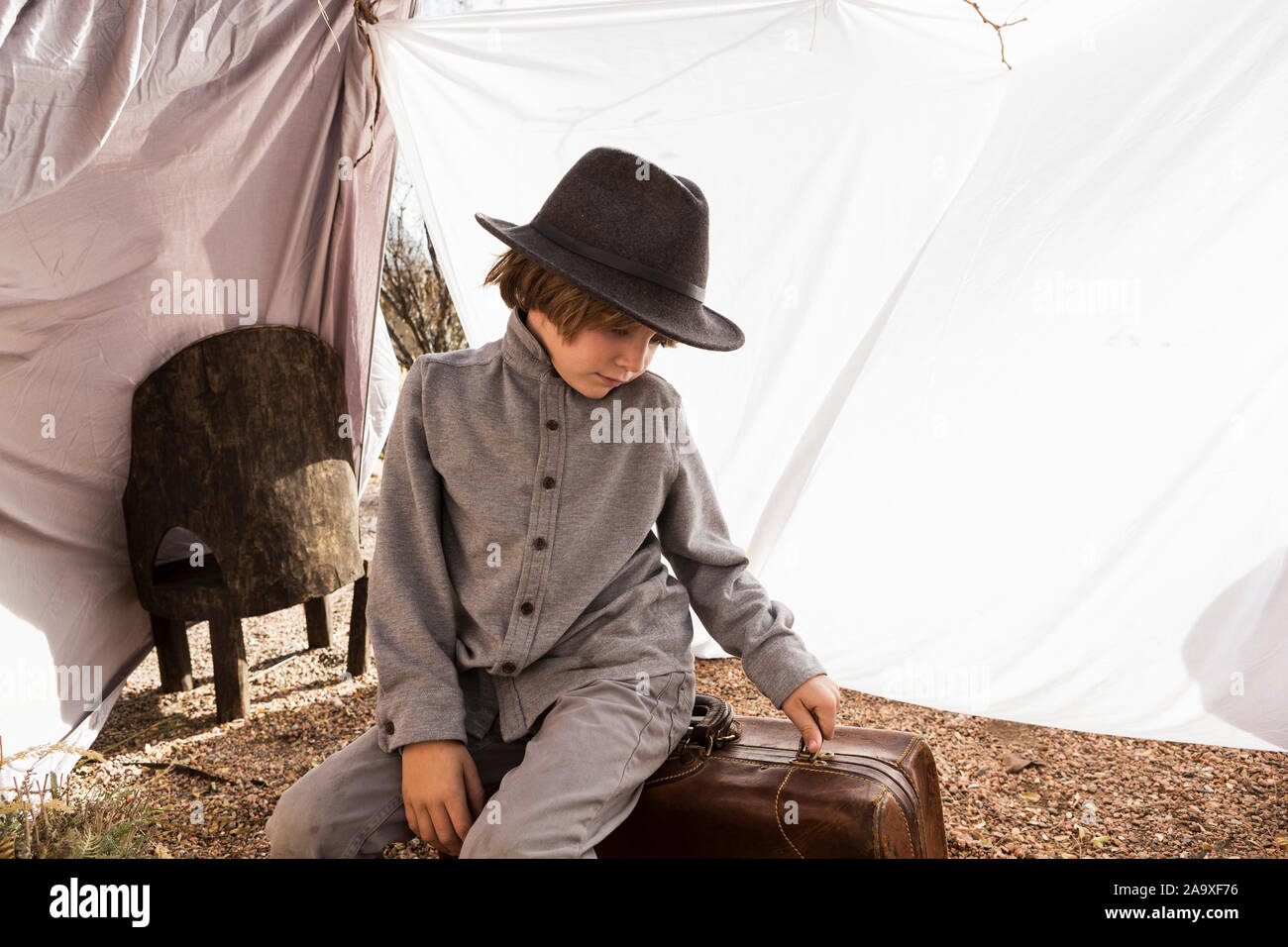 6 year old boy playing in an outdoor tent made of sheets Stock Photo