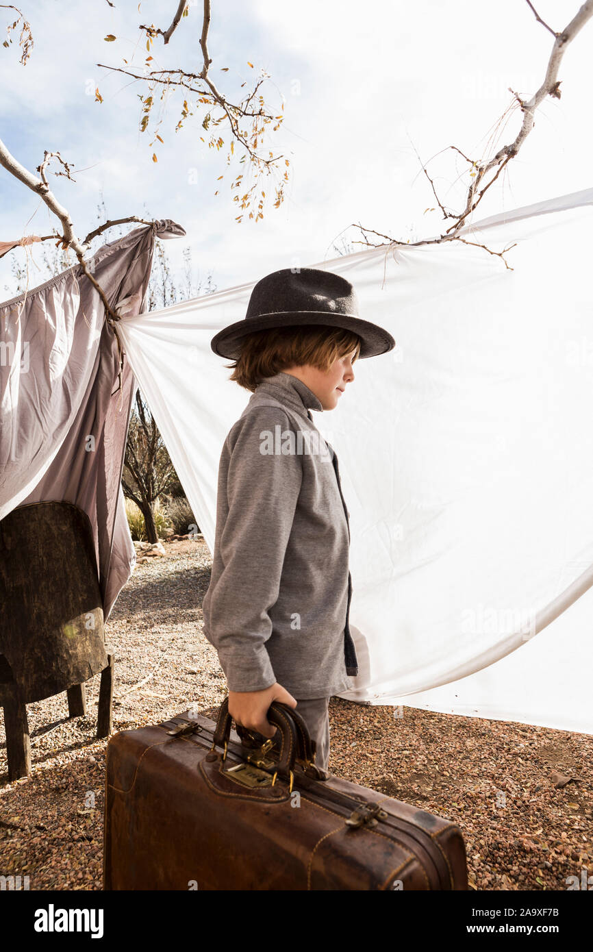 6 year old boy playing in an outdoor tent made of sheets Stock Photo