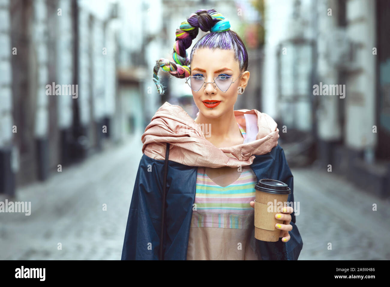 Cool funky hipster young woman with crazy avant garde look walking on city streets Stock Photo
