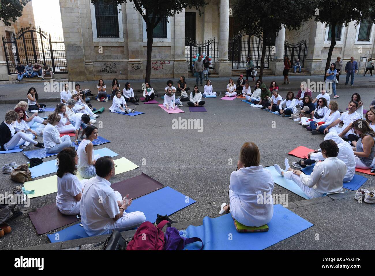 *** STRICTLY NO SALES TO FRENCH MEDIA OR PUBLISHERS *** November 17, 2019 - Beirut, Lebanon: A group of Lebanese protesters hold a meditation class in the street near Martyrs' Square, quietly practicing breathing exercices as their leader repeats the mantra 'Love, kindness, peace'. The meditation took place in the morning of a mass rally celebrating the one month-anniversary of the beginning of the Lebanese revolution. Un groupe de manifestants libanais pratiquent la meditation dans la rue pres de la Place des Martyrs, quelques heures avant une grande manifestation pour marquer les 1 mois du s Stock Photo