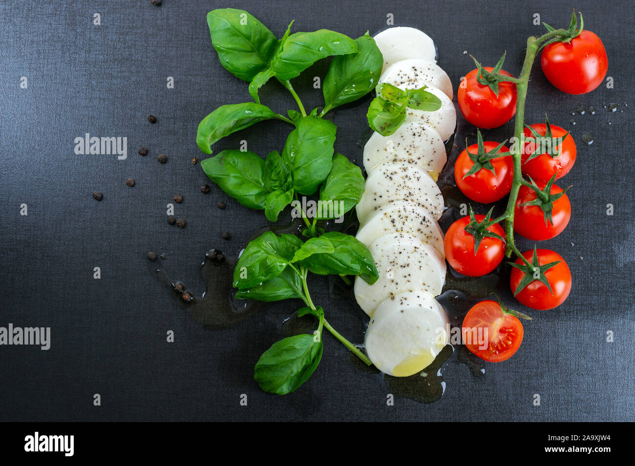 Italian food. Frseh basil, mozzarella, tomato, black pepper and olive oil. Stock Photo