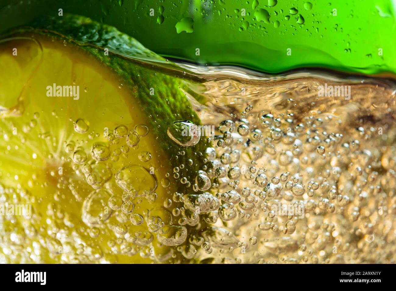 Carbonated drink or cocktail with lime, abstract splashing. Macro shot. Stock Photo