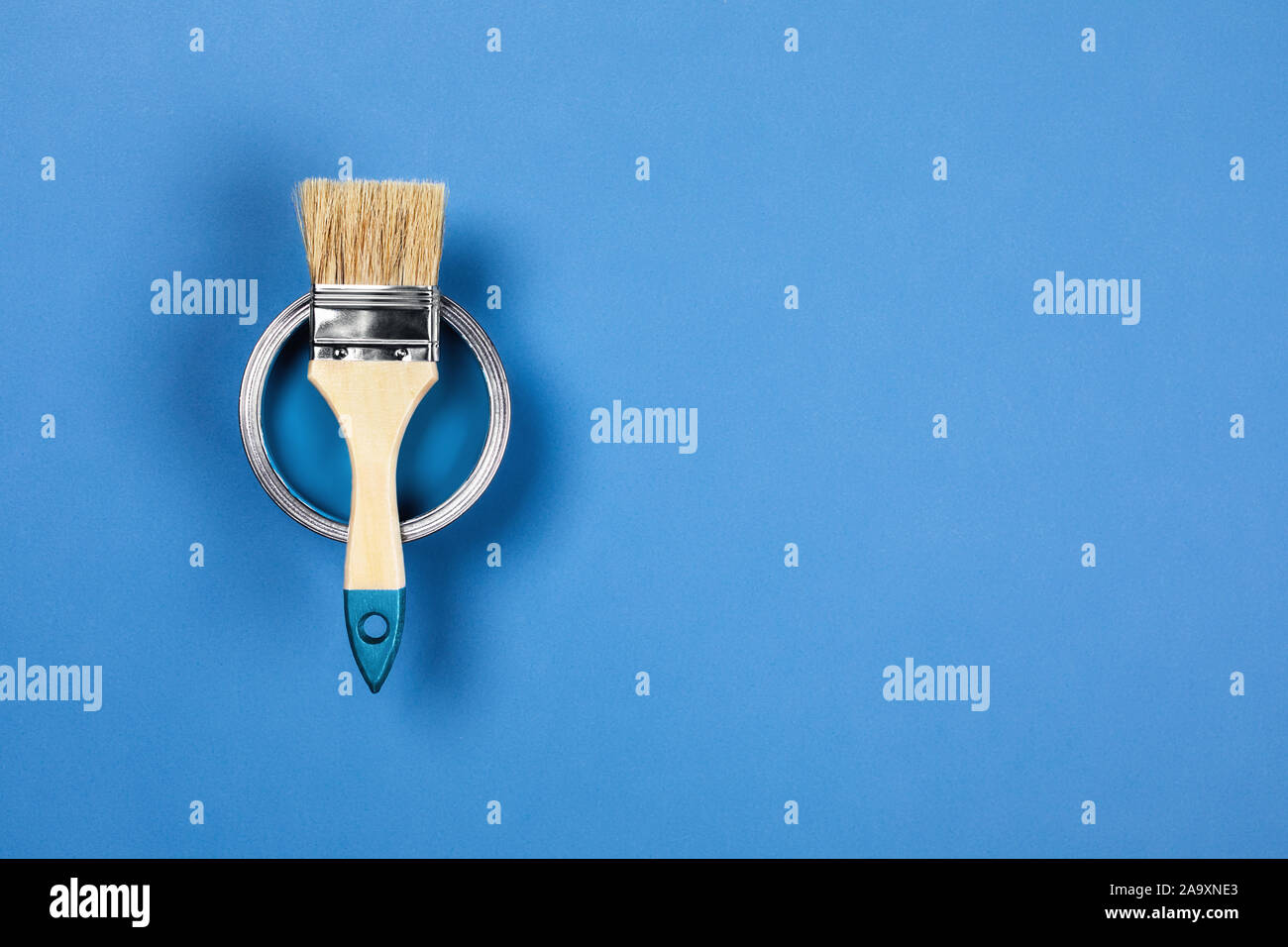 Renovation concept. Blue background with color paint jar and one brush. Flat lay, top view, copy space. Stock Photo